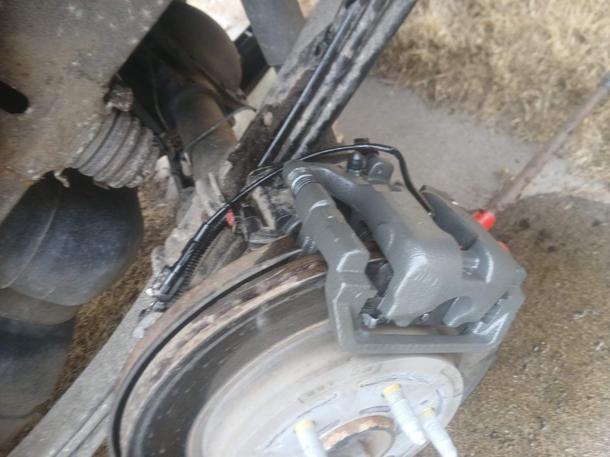 New brake caliper and brake line installed on a truck
